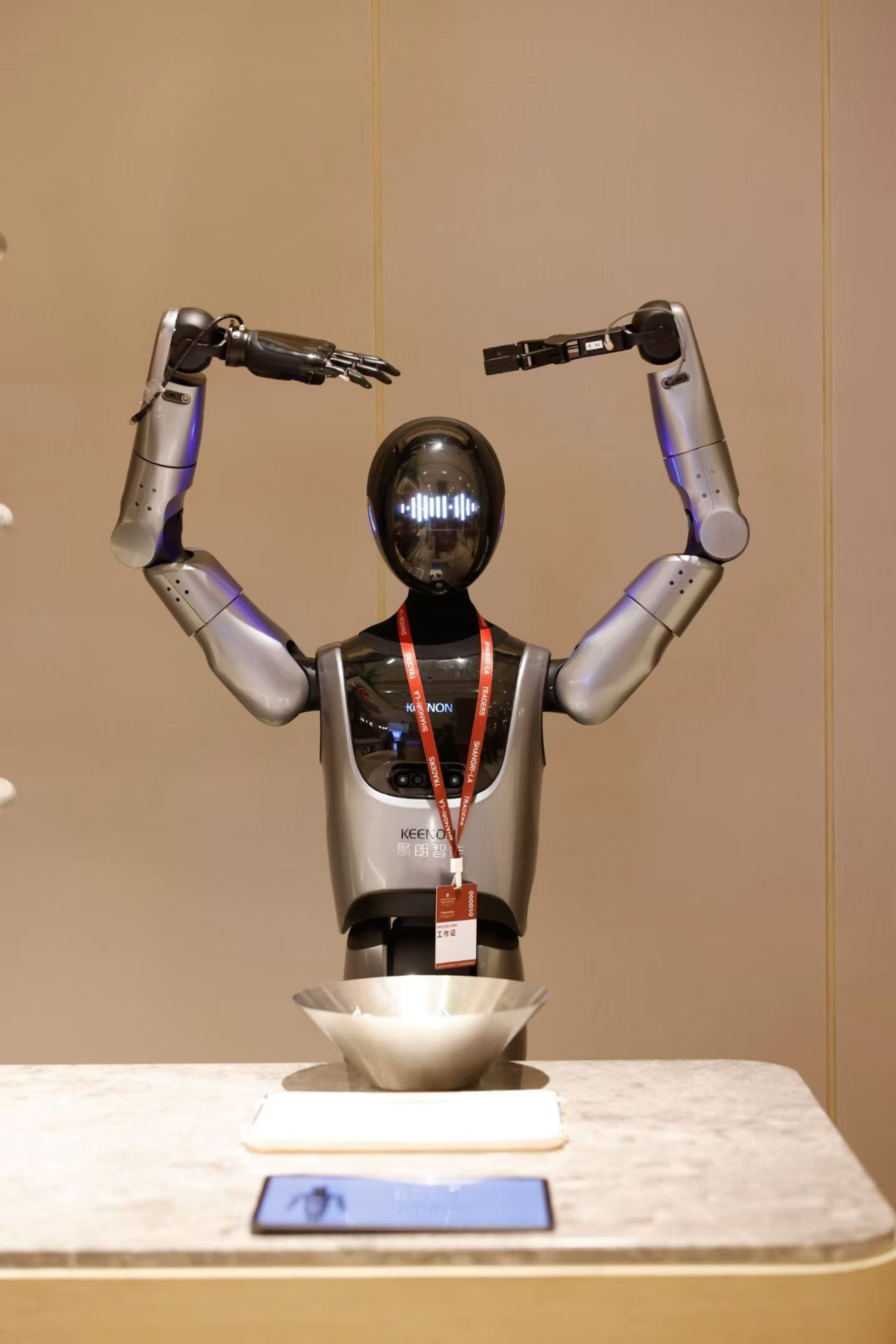 KEENON XMAN-R1 humanoid service robot raising both arms while interacting with guests